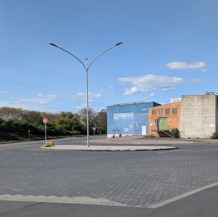 Gebäude und Verkehrsinsel im mneschenleern Niehler Hafen