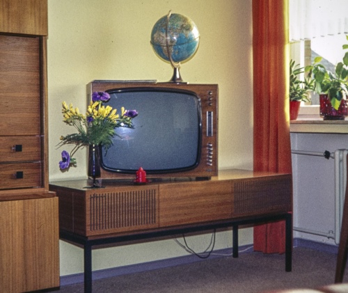 Eine 60er Jahre Musiktruhe, auf der ein Fernseher steht, darauf steht ein Globus